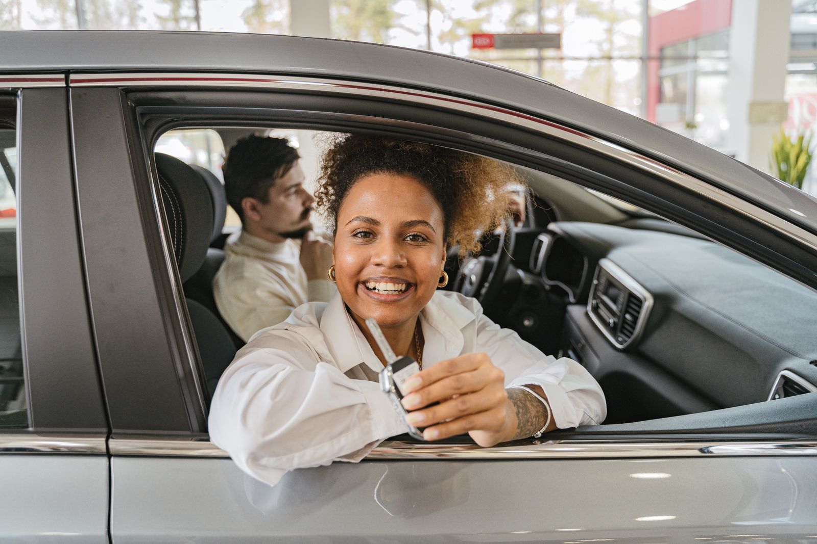 Buyer holding the keys to a car she has just bought